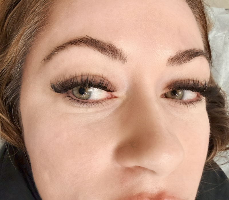 A happy client showing off her healed permanent eyeliner